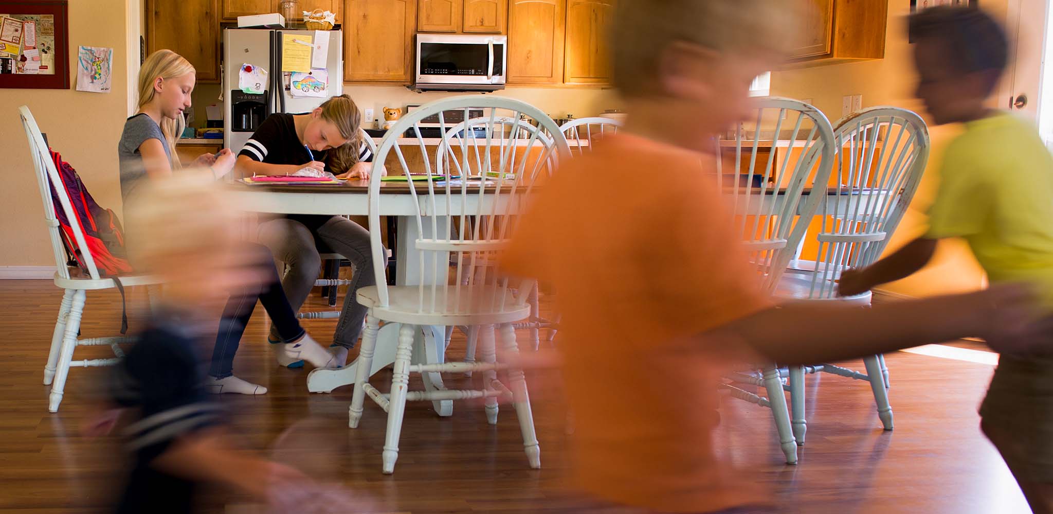  Elisa Danielson, center, and her sister McKenzie, left, finish their school homework as their brothers play. Danielson is the eldest of five siblings and will turn 15 on September 11, 2016. Leah Hogsten | The Salt Lake Tribune